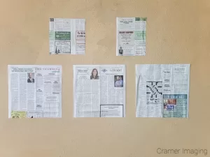 Cramer Imaging's photograph of newspaper templates on the wall arranged to hang a gallery wall presentation