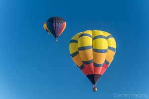 Cramer Imaging's fine art photograph of three hot air balloons taking flight in Panguitch Utah with a blue morning sky