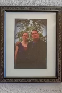 Photograph of a framed and matted photo of a couple hanging on the wall by Cramer Imaging