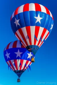 Cramer Imaging's fine art photograph of two patriotic hot air balloons flying close together in the sky