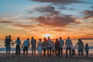 Extended family on the beach enjoying the sunset together