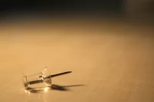 Photograph of a clear thumbtack sitting on a surface