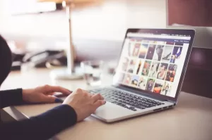 Photograph of a female using a laptop on a work surface