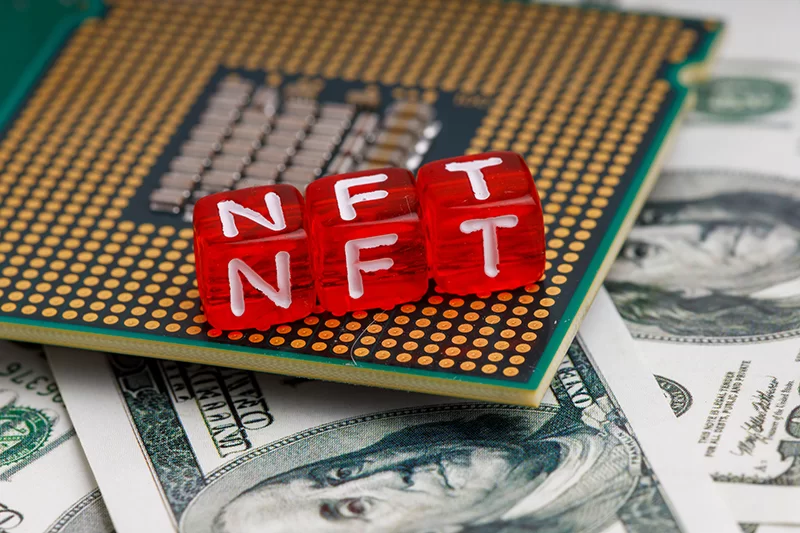 Photograph of NFT on a computer chip sitting on $100 bills