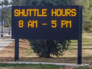 Photograph of a digital sign advertising the Bryce Canyon Shuttle service hours