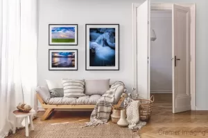 Photograph of 3 Cramer Imaging landscape pictures displayed on a gallery wall according to subject matter theme