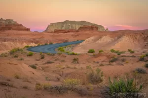 Cramer Imaging's fine art landscape photograph of sunset over a curved desert road in Goblin Valley State Park Utah