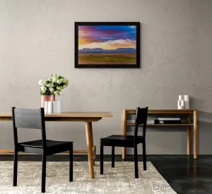 Photograph of a neutral dining area with a Cramer Imaging's "Open Range" on the wall and white flowers