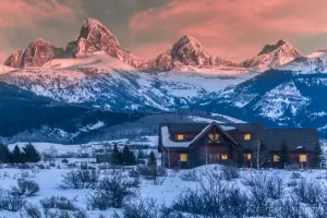 Cramer Imaging's professional quality landscape photograph of the Teton mountains and a cabin at sunset during winter