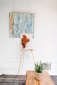 Picture of abstract art on an easel and a wall in a living area