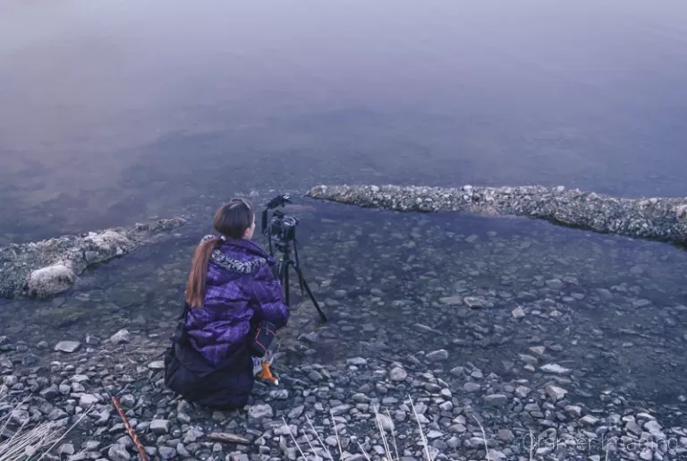 Landscape photographer Audrey Cramer setting up a landscape photo at Henry's Lake Idaho