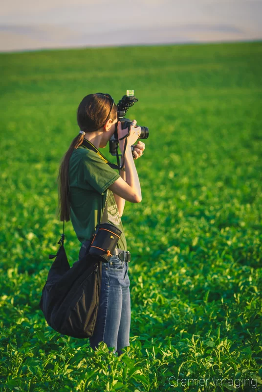 Audrey Cramer Photography's behind-the-scenes photo of Audrey with a camera in a potato field in Idaho
