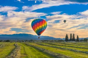 Cramer Imaging's fine art photograph of two hot air balloons taking flight in Panguitch Utah over a farm field and mountains