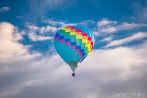 Cramer Imaging's fine art photograph of one colorful hot air balloon taking flight in Panguitch Utah with a blue morning sky