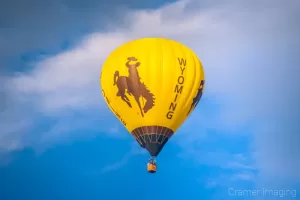 Cramer Imaging's fine art photograph of the Wyoming hot air balloon taking flight in Panguitch Utah with a partly cloudy morning sky