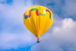 Cramer Imaging's fine art photograph of one yellow hot air balloon taking flight in Panguitch Utah with a cloudy morning sky