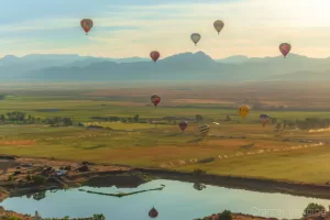 Cramer Imaging's fine art aerial photograph of three hot air balloons flying over a field and reflecting in a pond in Panguitch Utah