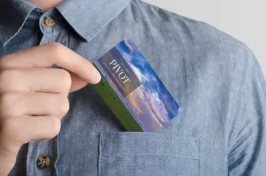 Mockup of a business card featuring Cramer Imaging landscape photography being placed into the shirt pocket of a man's shirt