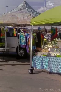 Photo of an outdoor farmer's market with art and other merchandise for sale