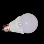 Photograph of a single LED light bulb on its side on a black background by Cramer Imaging