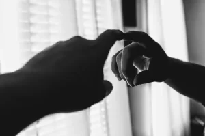 Monochrome or black and white photo of a finger pointed at a mirror