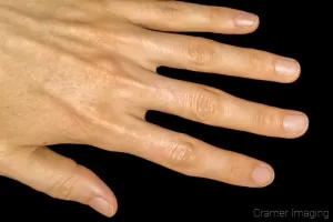 Photograph of a hand on a black background by Cramer Imaging