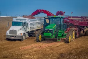 Cramer Imaging's commercial landscape photograph of farm machinery harvesting potatoes in a field