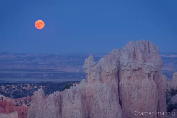 Cramer Imaging's fine art landscape closeup photograph of a red moon rising over a rock formation of Bryce Canyon National Park Utah