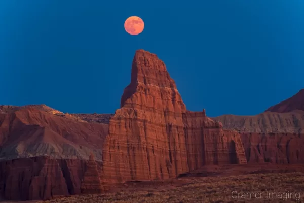 Cramer Imaging's professional landscape photograph of a red moon rising over the Temple of the Moon in Capitol Reef National Park Utah