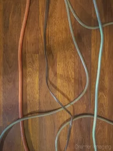 Photograph of several electrical cords on the floor which can be a tripping hazard in a studio