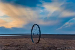 Cramer Imaging's fine art landscape photograph of wheel line irrigation equipment against a dramatic sunset sky in wintertime in Idaho