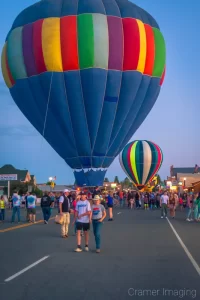 Fine art photograph of inflated hot air balloons and a crowd for a balloon glow on Main Street, Panguitch, Utah by Cramer Imaging