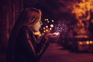 Image of a girl blowing magic dust or pixie dust from her cupped hands