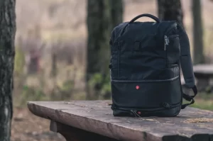 Photograph of a camera backpack sitting on s wooden table outside