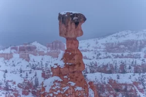 Cramer Imaging's fine art close-up landscape photograph of Thor's Hammer hoodoo with snow and misty background in Bryce Canyon National Park Utah