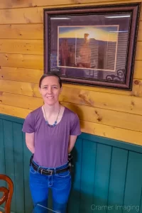 Photo of landscape photographer Audrey Cramer and her photo titled "Forged" at the Backroads Bistro in Panguitch, Utah