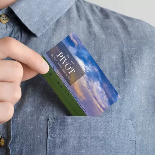 Mockup of a business card featuring Cramer Imaging landscape photography being placed into the shirt pocket of a man's shirt